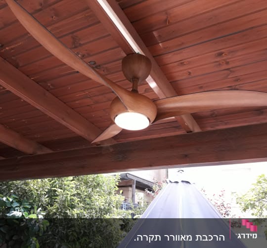 מאוורר תקרה מעץ עם תאורה מותקן על תקרה מעץ
